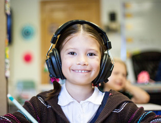 a little girl with headphones smiling